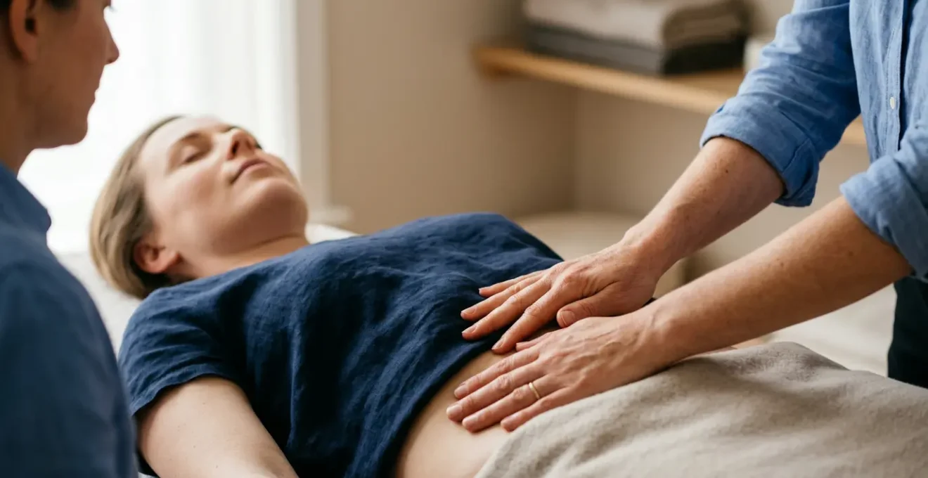 Mains d'ostéopathe posées délicatement sur l'abdomen d'une patiente pour une manipulation douce des fascias